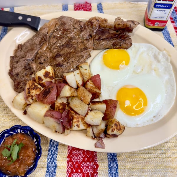 Aquino's Birrieria & Brunch steak and eggs with breakfast potatoes and salsa on a striped placemat.