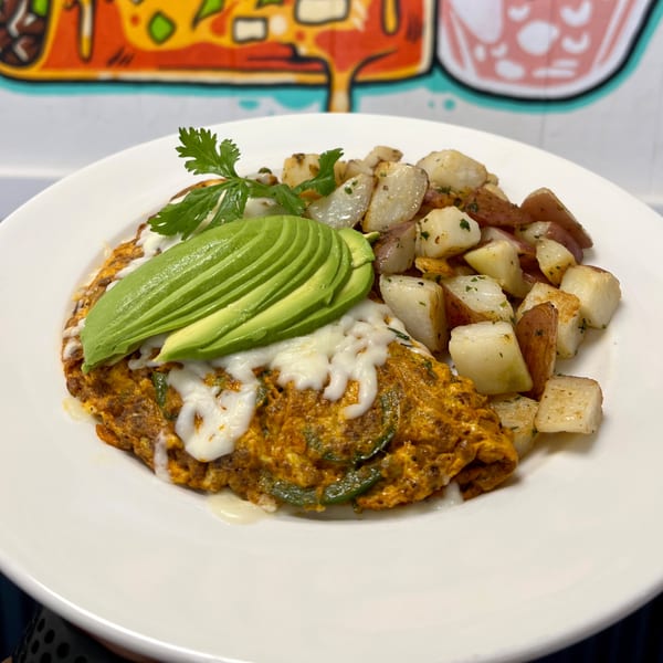 Aquino's Birrieria & Brunch's omelet with avocado, melted cheese, and a side of roasted potatoes.